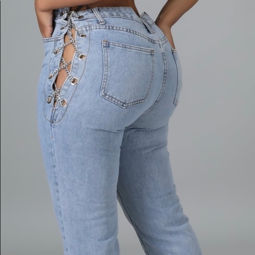 Non-stretch light blue jeans with adjustable side chain detail.